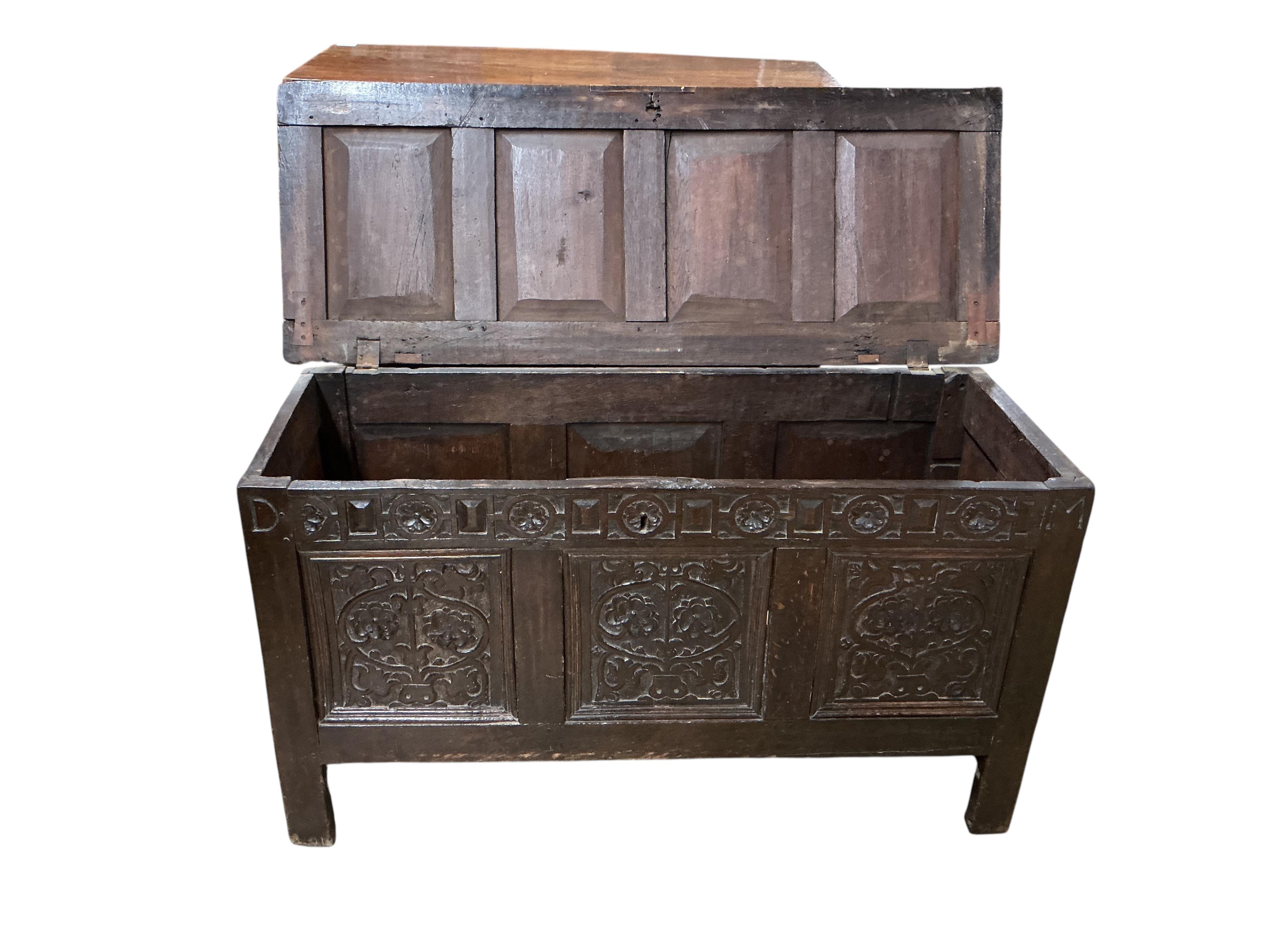 A late 17th century carved oak triple panelled coffer, the top rail monogrammed D.M, width 128cm, depth 48cm, height 68cm